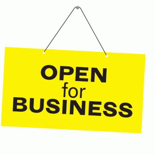 A Yellow Sign That Says Open For Business Hangs On A String GIF
