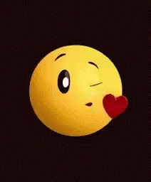 A Yellow Smiley Face Is Blowing A Kiss With A Red Heart On Its Nose . GIF