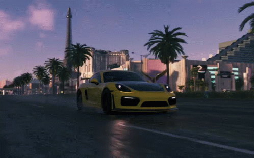 A Yellow Sports Car Is Driving Down A Wet Road GIF