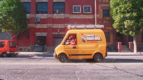 A Yellow Super Mario Bros Plumbing Van Drives Down A City Street GIF