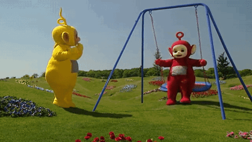 A Yellow Teddy Bear And A Red Teddy Bear Standing Next To A Swing Set GIF