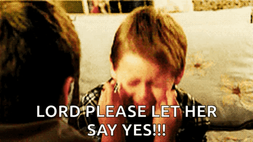 A Young Boy Covering His Face With His Hands While A Man Says Lord Please Let Her Say Yes !!! GIF