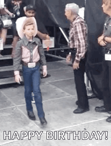 A Young Boy Dressed As A Cowboy Is Walking Towards A Man In A Cowboy Hat . GIF