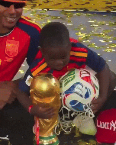 a young boy holds a soccer ball in front of a trophy that says lamin