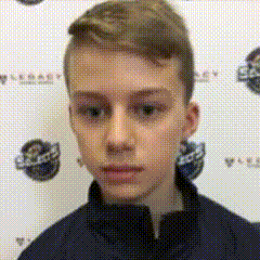 A Young Boy In A Blue Jacket Is Standing In Front Of A Wall With A Logo On It . GIF