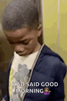 A Young Boy In A Blue Jacket Is Standing In Front Of A Yellow Wall And Says `` I Had Said Good Morning '' . GIF