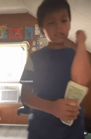 A Young Boy In A Blue Shirt Is Holding A Book In His Hands With The Words Togethershoeshoes Written On The Bottom GIF