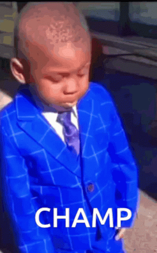 A Young Boy In A Blue Suit And Tie With The Word Champ On The Bottom GIF