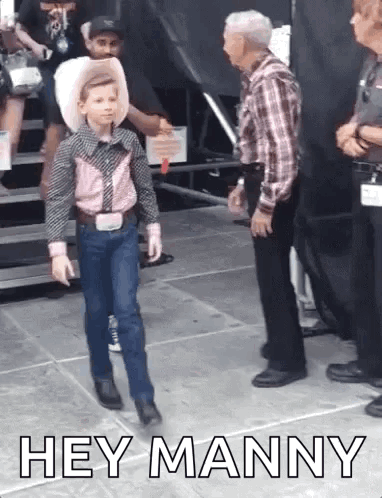 A Young Boy In A Cowboy Outfit Is Walking In Front Of A Man . GIF
