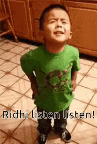 A Young Boy In A Green Shirt Is Standing On A Tiled Floor With The Words Ridhi Listen Listen . GIF