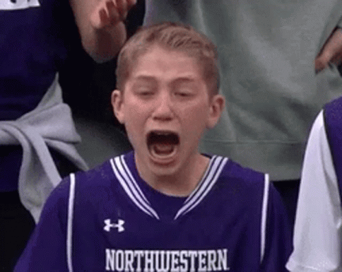 A Young Boy In A Purple Northwestern Jersey Is Crying While Watching A Basketball Game . GIF