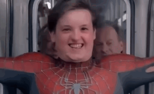 A Young Boy In A Spiderman Costume Is Smiling While Sitting On A Bus . GIF