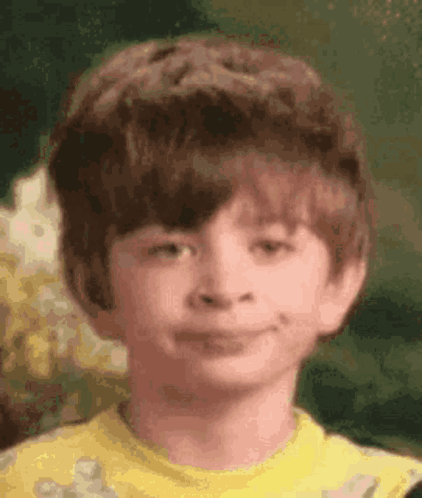 A Young Boy In A Yellow Shirt Smiles For The Camera GIF