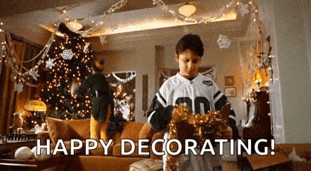 A Young Boy Is Decorating A Living Room For Christmas . GIF