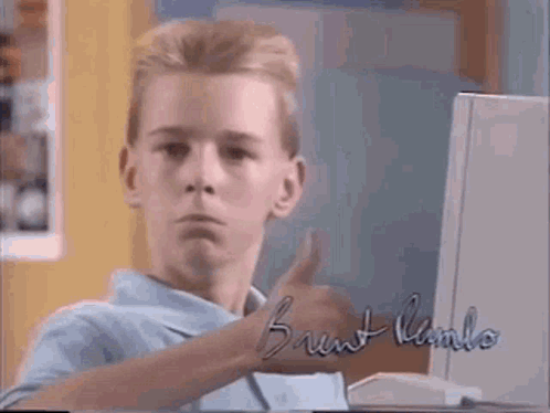 A Young Boy Is Giving A Thumbs Up In Front Of A Computer With The Name Brent Kamlo On It GIF