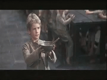 A Young Boy Is Holding A Bowl Of Soup With A Spoon In His Hand . GIF