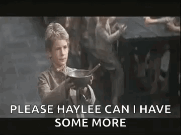 A Young Boy Is Holding A Bowl With A Spoon In It And Asking For Some More . GIF