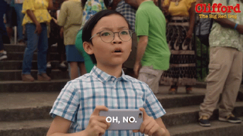 A Young Boy Is Holding A Cell Phone That Says Oh No On It GIF