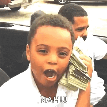 A Young Boy Is Holding A Large Stack Of Money In His Hand . GIF