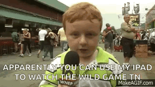 A Young Boy Is Holding A Microphone And Talking Into It While Standing In Front Of A Crowd . GIF