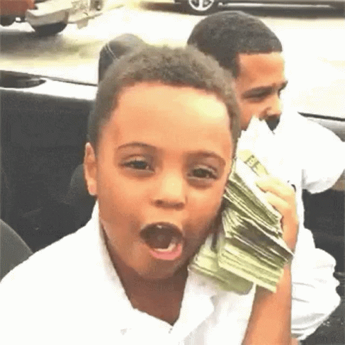 A Young Boy Is Holding A Stack Of Money In His Hand And Making A Funny Face . GIF