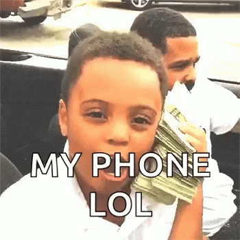 A Young Boy Is Holding A Stack Of Money In His Hand And Talking On A Cell Phone . GIF