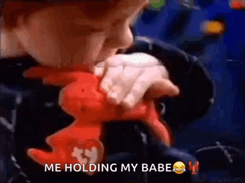 A Young Boy Is Holding A Stuffed Animal And Says Me Holding My Babe . GIF