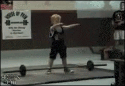 A Young Boy Is Lifting A Barbell In Front Of A Sign That Says House Of Fun GIF