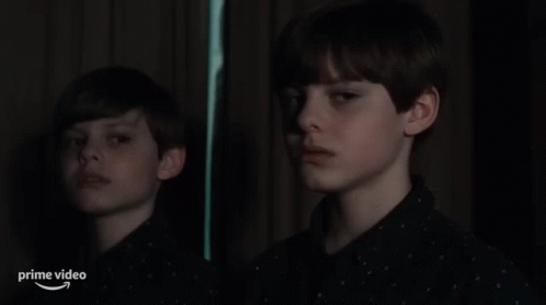A Young Boy Is Looking At His Reflection In A Mirror With The Words Prime Video Below Him GIF