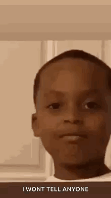A Young Boy Is Making A Funny Face And Saying `` I Won 'T Tell Anyone '' . GIF