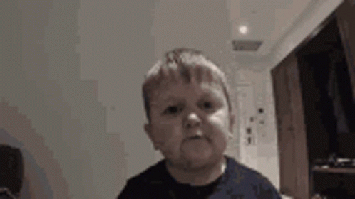 A Young Boy Is Making A Funny Face While Looking At The Camera . GIF