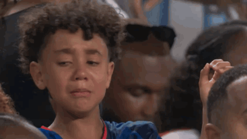 A Young Boy Is Making A Heart Shape With His Hands GIF