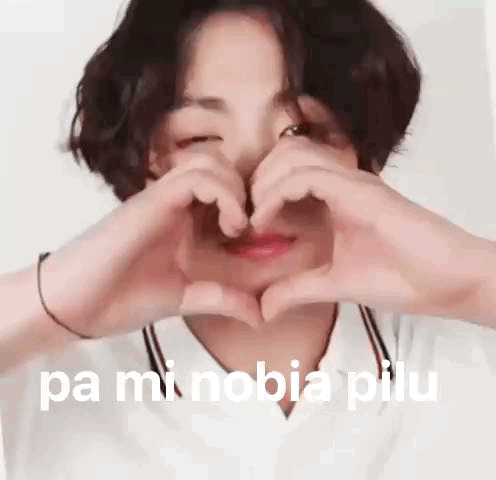 A Young Boy Is Making A Heart Shape With His Hands . GIF
