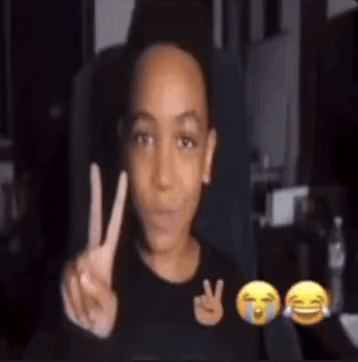 A Young Boy Is Making A Peace Sign In Front Of A Screen With Emojis . GIF