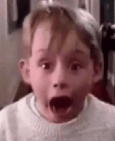 A Young Boy Is Making A Surprised Face With His Mouth Wide Open . GIF