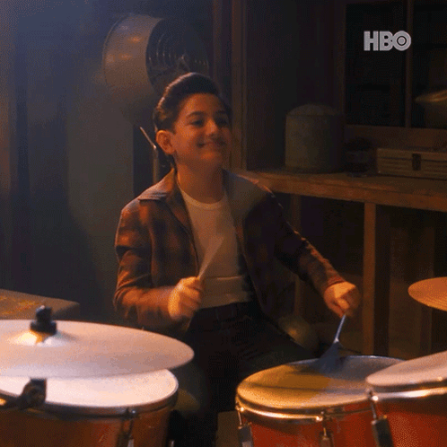 A Young Boy Is Playing Drums With A Hbo Logo In The Background GIF