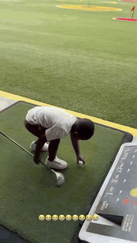 A Young Boy Is Playing Golf On A Driving Range . GIF