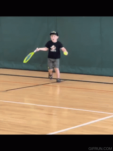 A Young Boy Is Playing Tennis On A Court With A Gifrun.com Logo In The Corner GIF