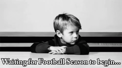 A Young Boy Is Sitting At A Table Waiting For Football Season To Begin . GIF