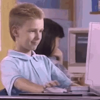 A Young Boy Is Sitting In Front Of A Computer . GIF