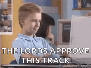 A Young Boy Is Sitting In Front Of A Computer Screen With The Words `` The Lords Approve This Track '' Written On It . GIF