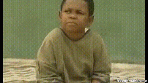 A Young Boy Is Sitting On A Bed And Making A Face . GIF