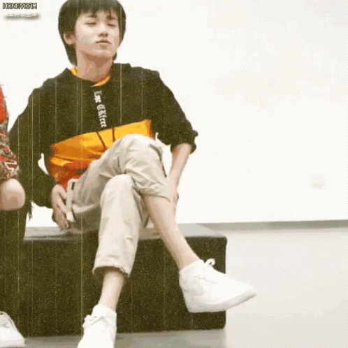 Boy Sitting Cross-Legged On Bench GIF