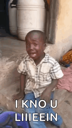 A Young Boy Is Sitting On The Ground With His Mouth Open And Making A Funny Face . GIF