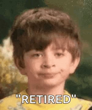 a young boy is smiling and saying `` retired '' in a close up of his face .