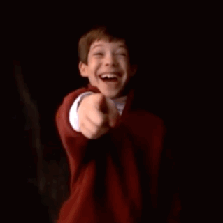 A Young Boy Is Smiling While Holding A Can Of Soda . GIF