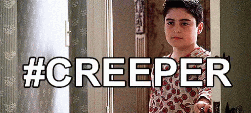 A Young Boy Is Standing In A Doorway With The Words #Creeper Behind Him GIF