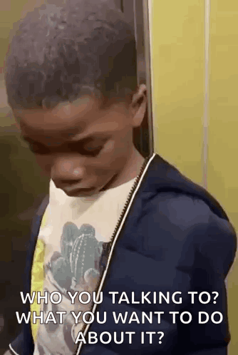 A Young Boy Is Standing In An Elevator Talking To Someone . GIF