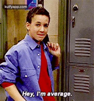 A Young Boy Is Standing In Front Of A Locker And Talking On A Cell Phone . GIF