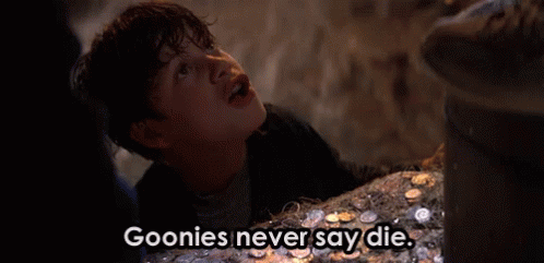 A Young Boy Is Standing In Front Of A Pile Of Coins And Says Goonies Never Say Die . GIF